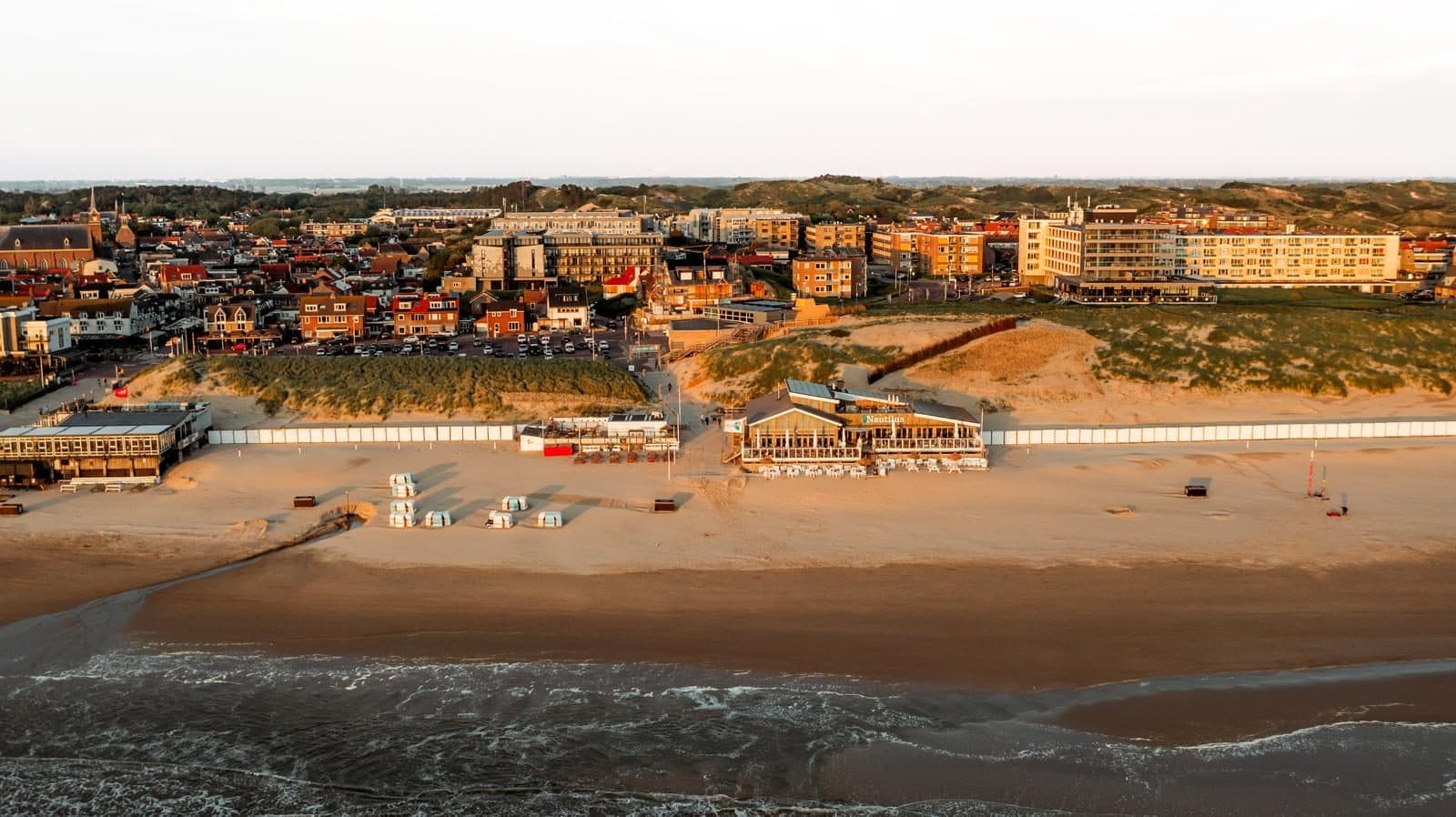 Luchtfoto van Egmond aan Zee: strand, strandpaviljoens, boulevard en dorp