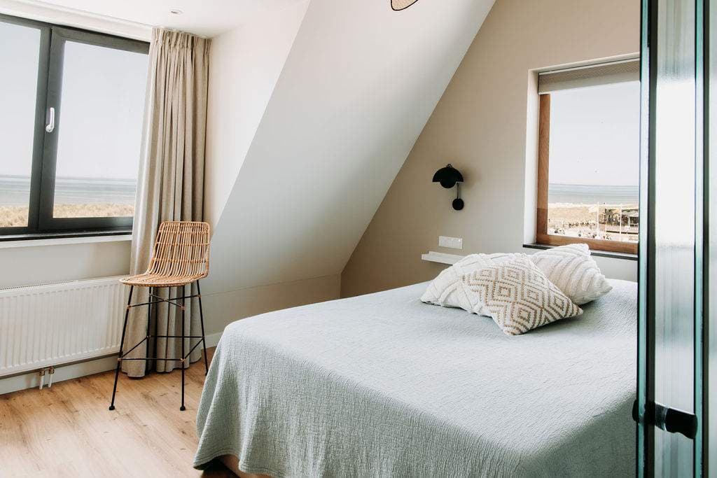 Schlafzimmer mit zwei Fenstern und Meerblick