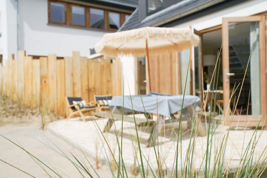 Terras met parasol door het helmgras